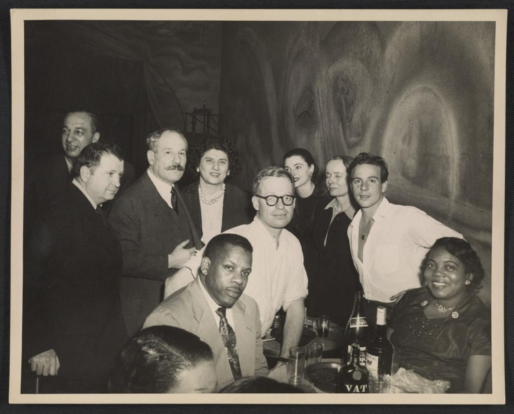 A group of people posing for a photo, gathered around a table at a formal occasion