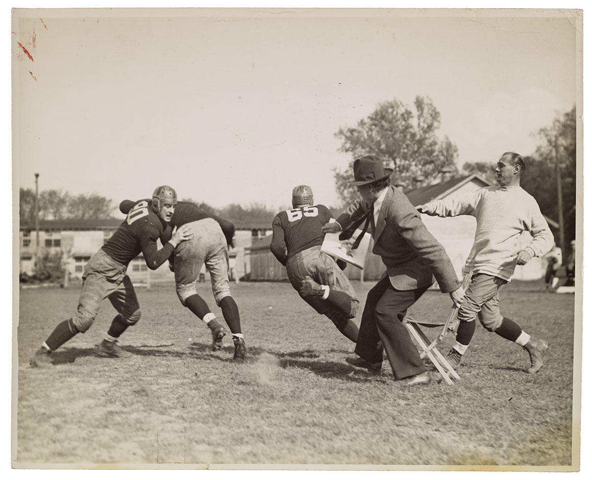 Artist john Steuart Curry sketching on the sidelines of a football practice