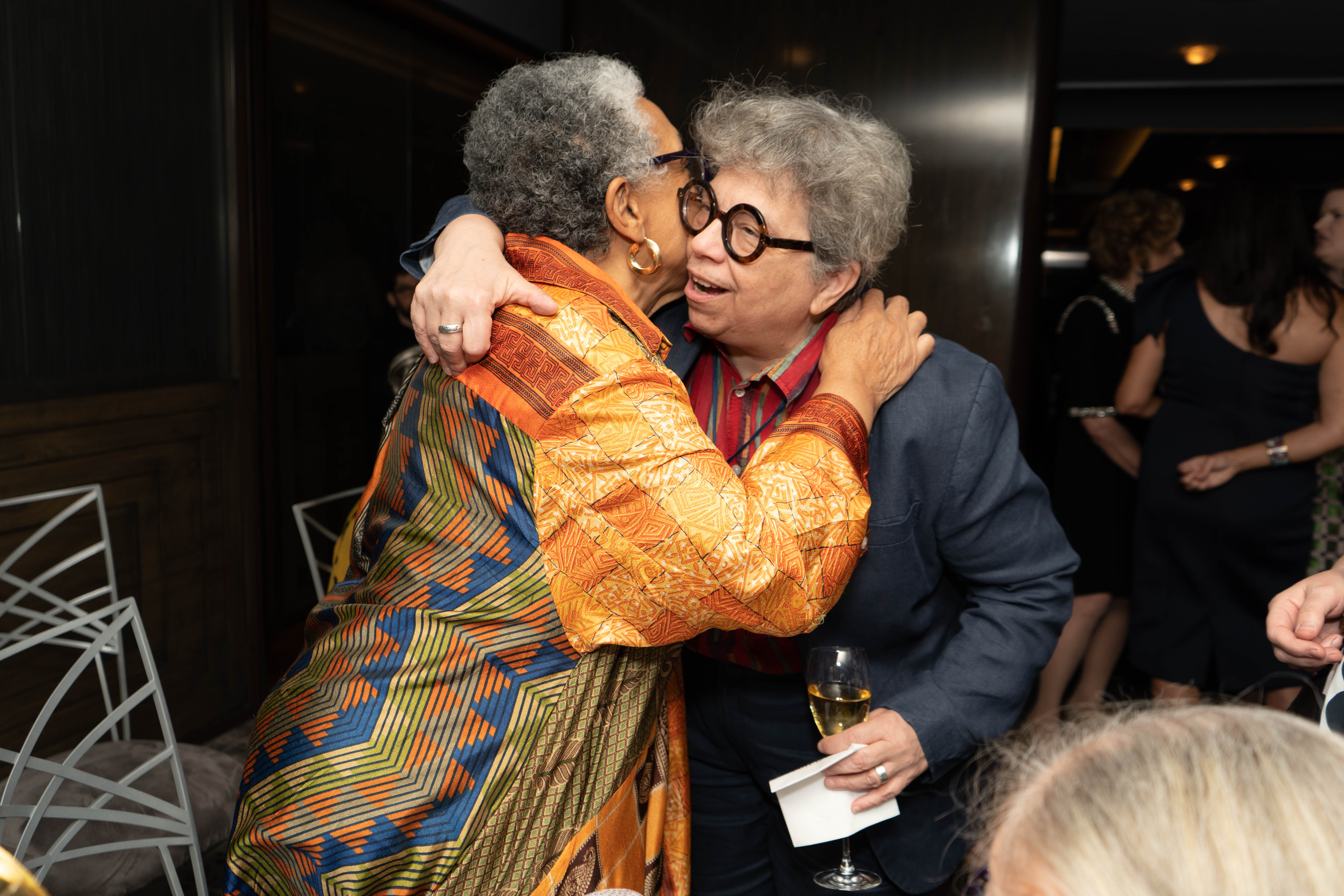 Lowery Stokes Sims and Sheila Pepe embrace during the cocktail hour.