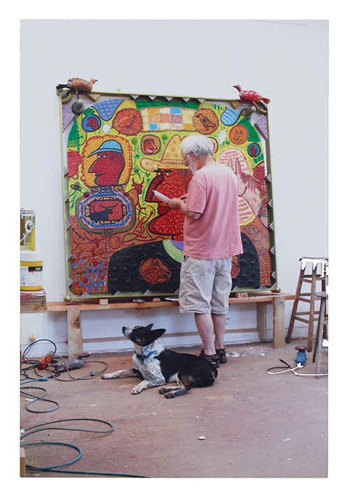 Photograph of Roy De Forest in his studio with his dog Cato