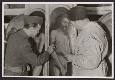 U.S. Army Monuments Men Lieutenant Daniel J. Kern and German art conservator Karl Sieber examining a panel of the Ghent Altarpiece looted by the Nazis and discovered  hidden in the Altaussee salt mines in Austria by the Monuments Men, 1945.  Thomas Carr Howe papers, Archives of American Art.