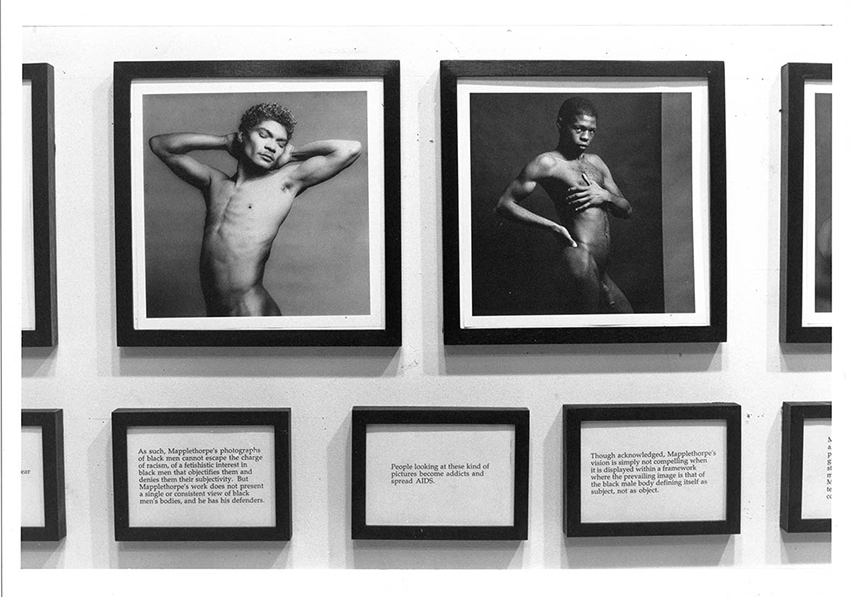 Detail of grayscale photograph of exhibition installatio of framed images and texts.