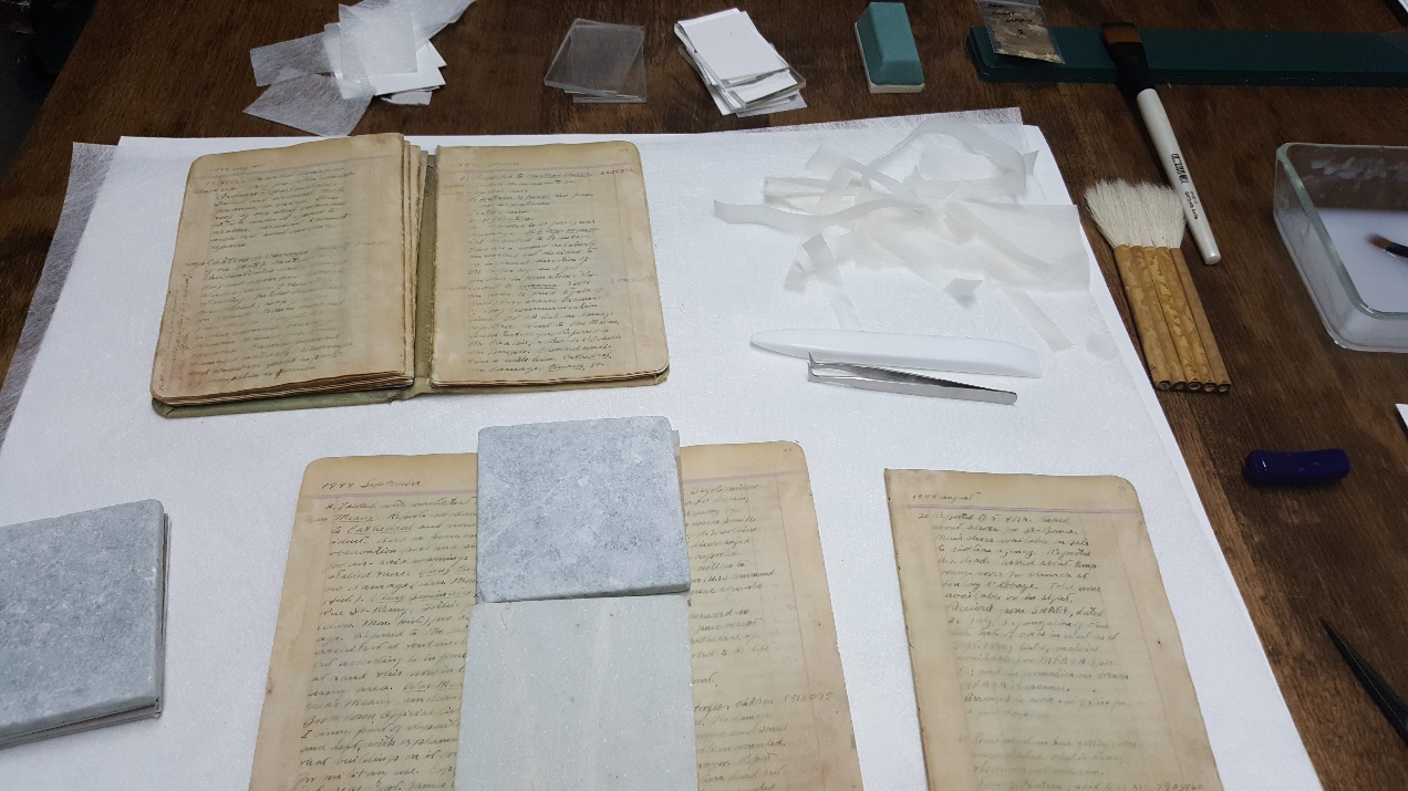 George Stout diary pages on a table during conservation process