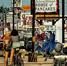 Detail of photograph of a collage featuring road signs from a busy roadside, two women on bikes, and figures from a medieval painting, including Mary and the baby Jesus riding a donkey. 